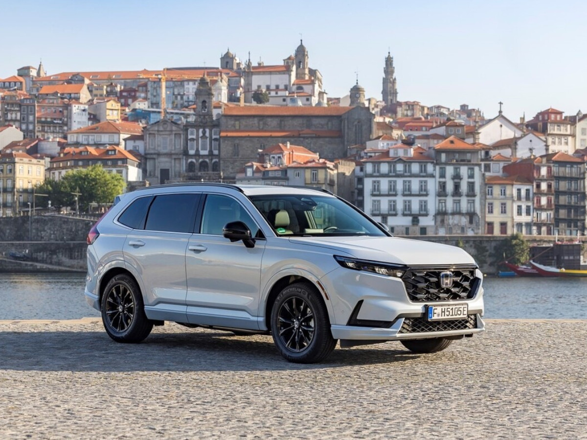 Honda CR-V Hybrid blanco aparcado en una ciudad a la vera de un río