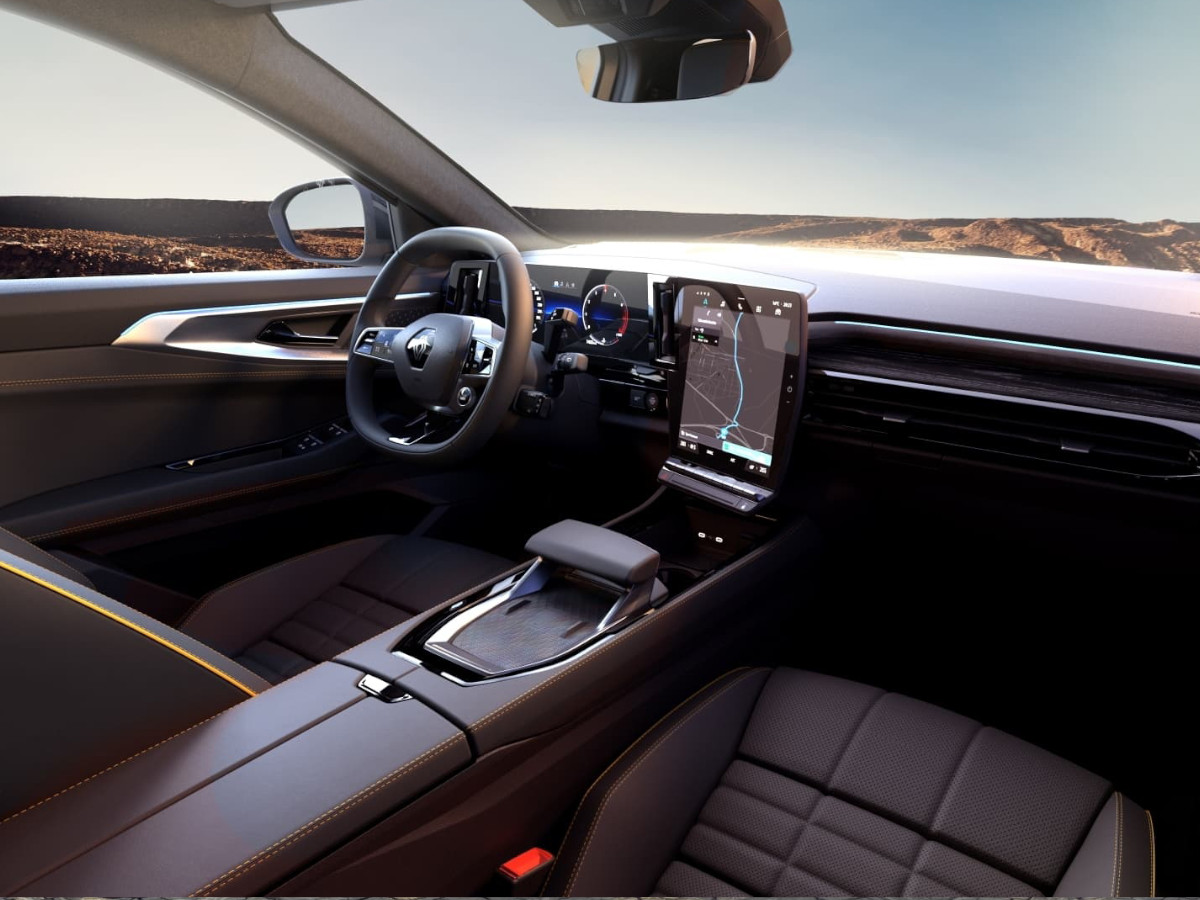 Interior del Renault Austral con volante a la izquierda, salpicadero en tonos oscuros, cuadro de instrumentos digital y gran pantalla central vertical mostrando el sistema de navegación.