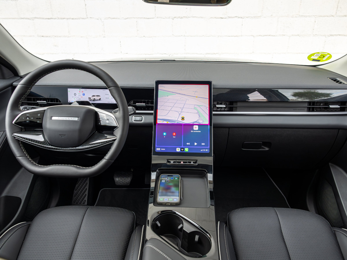 Interior del Jaecoo 5 visto desde las plazas traseras, con volante multifunción, instrumentación digital, gran pantalla táctil vertical y consola central con cargador inalámbrico.