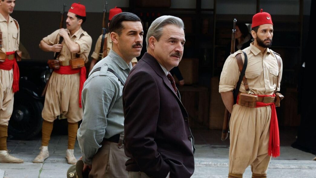 Alberto San Juan vestido con traje negro y Mario Casas de militar en una escena de la película La cena.