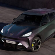 Los 8 mejores coches por 30.000 euros que puedes comprar en 2026 Coche eléctrico CUPRA Raval visto desde un ángulo frontal elevado, con carrocería en tonos verdes y morados, llantas deportivas y firma lumínica LED, estacionado en una plaza urbana de cemento