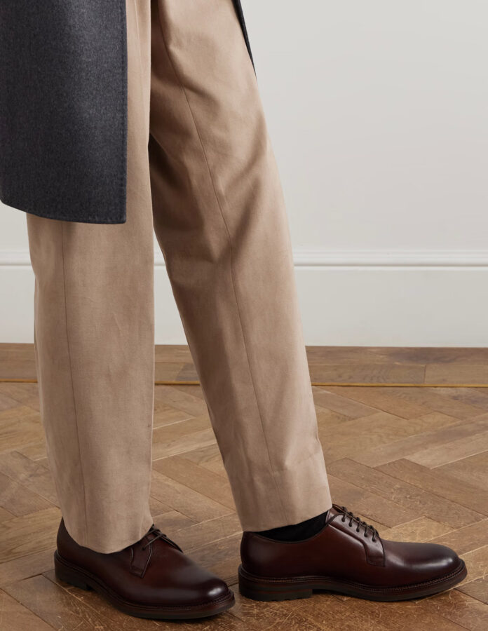 Look de un hombre vestido con unos zapatos de vestir modelo derby en color marrón