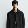 Modelo joven vestido con un look oscuro de Zara hombre