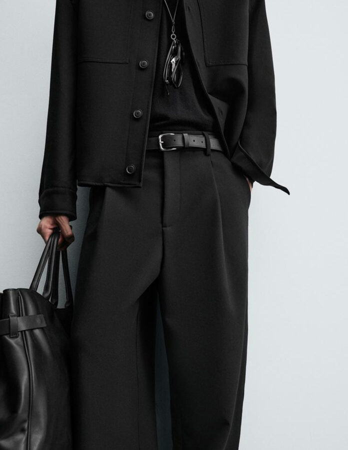 Plano detalle del modelo joven vestido con un look oscuro de Zara hombre, enfocado en la cintura
