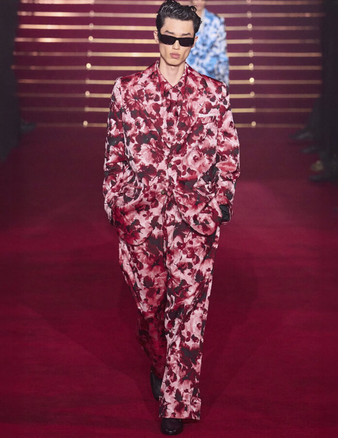 Modelo del desfile de Willy Chavarria desfilando en la pasarela con un look con estampado de flores.