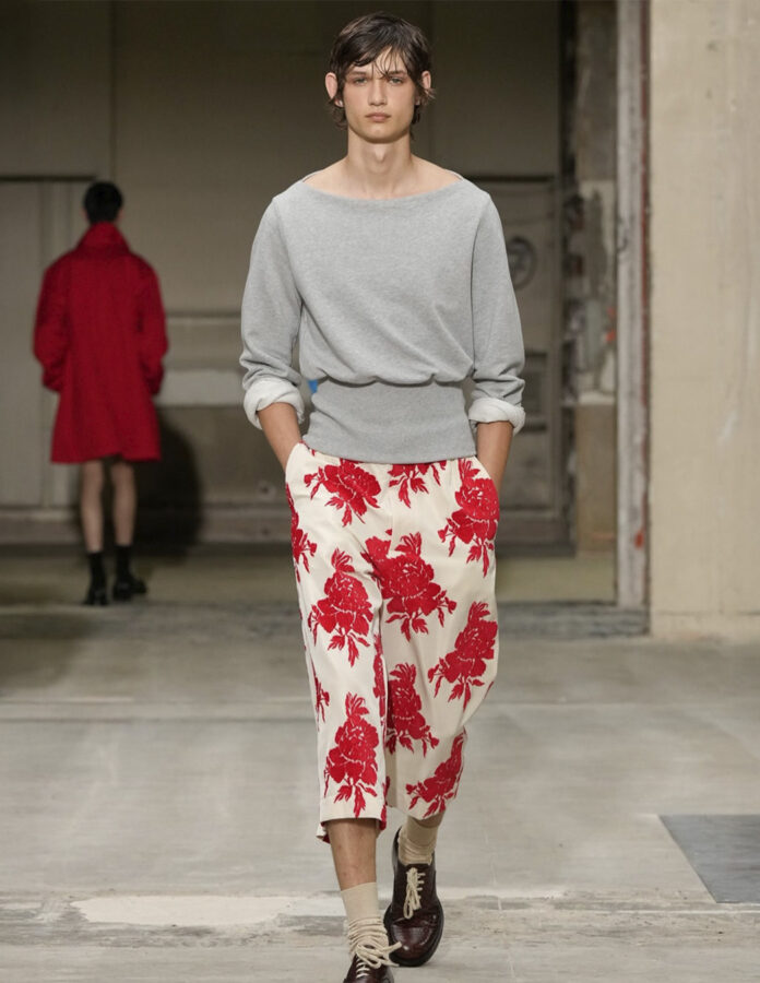 Modelo del desfile de Dries Van Noten desfilando en la pasarela con un look con estampado de flores.
