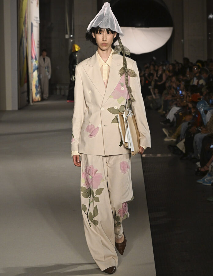 Modelo del desfile de KidSuper desfilando en la pasarela con un look con estampado de flores.