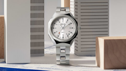 Zenith DEFY Revival A3643 con esfera plateada y brazalete escalera posado sobre planos técnicos