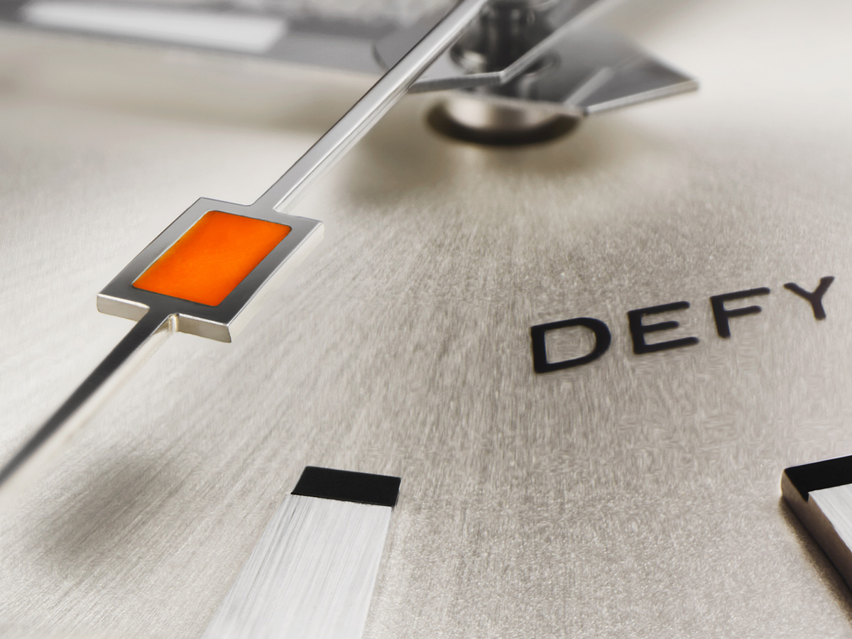 Detalle macro del segundero naranja y el logotipo DEFY en la esfera del Zenith DEFY Revival A3643
