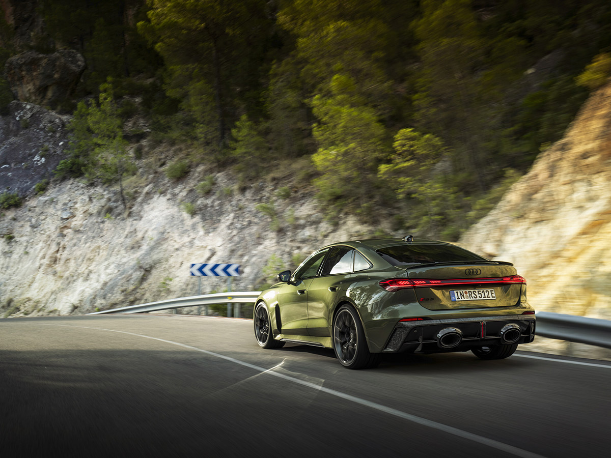Vista trasera del Audi RS 5 en carretera, con pilotos traseros OLED y doble salida de escape ovalada