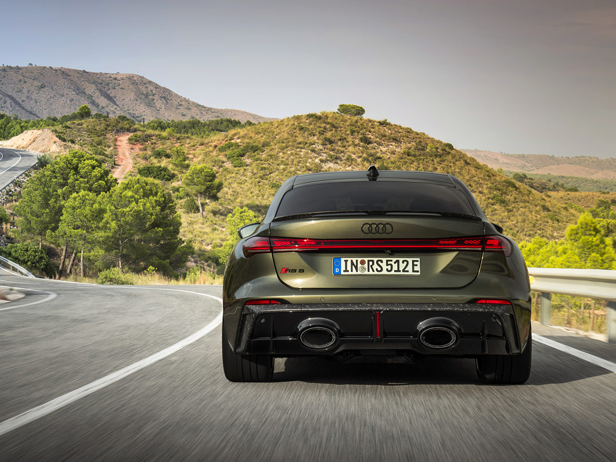 Audi RS 5 en marcha visto desde atrás en carretera de curvas, con difusor RS y salidas de escape ovaladas