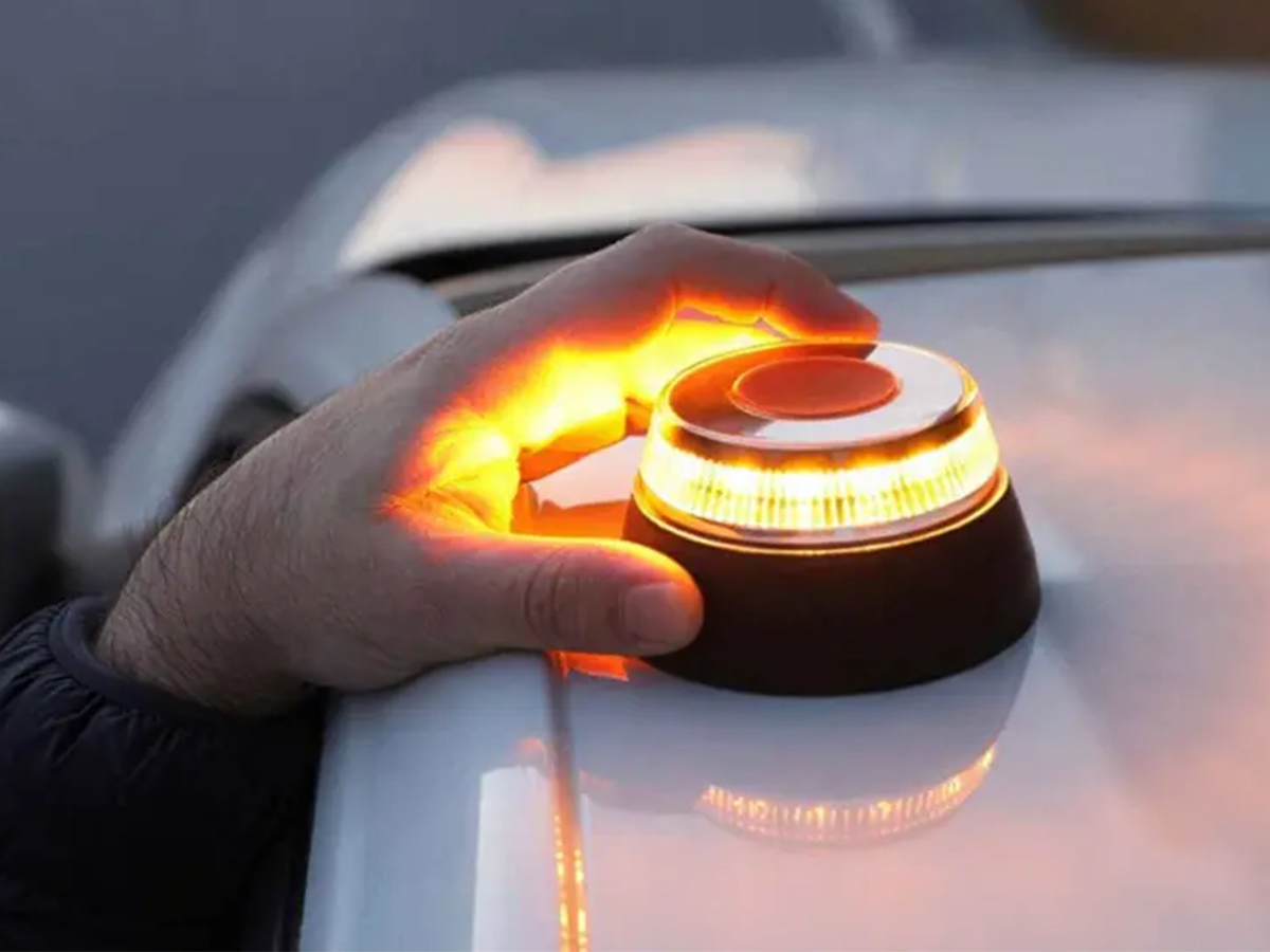 mano poniendo la baliza V16 obligatoria en España en coche