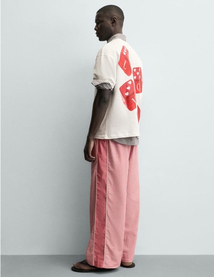 Modelo vestido con la camiseta blanca de Zara con estampado de dados en la espalda