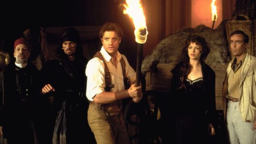Brendan Fraser con camiseta blanca sujetando una antorcha en la oscuridad junto a Rachel Weisz en La Momia.