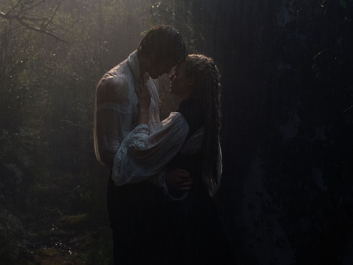 Jacob Elordi agarrando a Margot Robbie en una escena erótica con lluvia de fondo en Cumbres borrascosas.