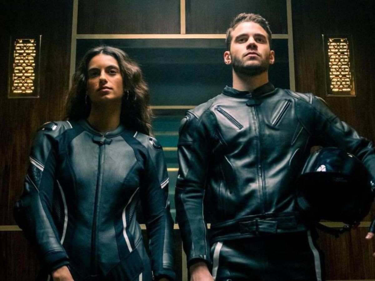 Begoña Vargas y Julio Peña con trajes de cuero en un ascensor en una escena de la serie Berlín en Netflix.