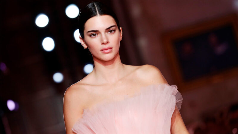 Kendall Jenner desfilando con un elegante vestido rosa.