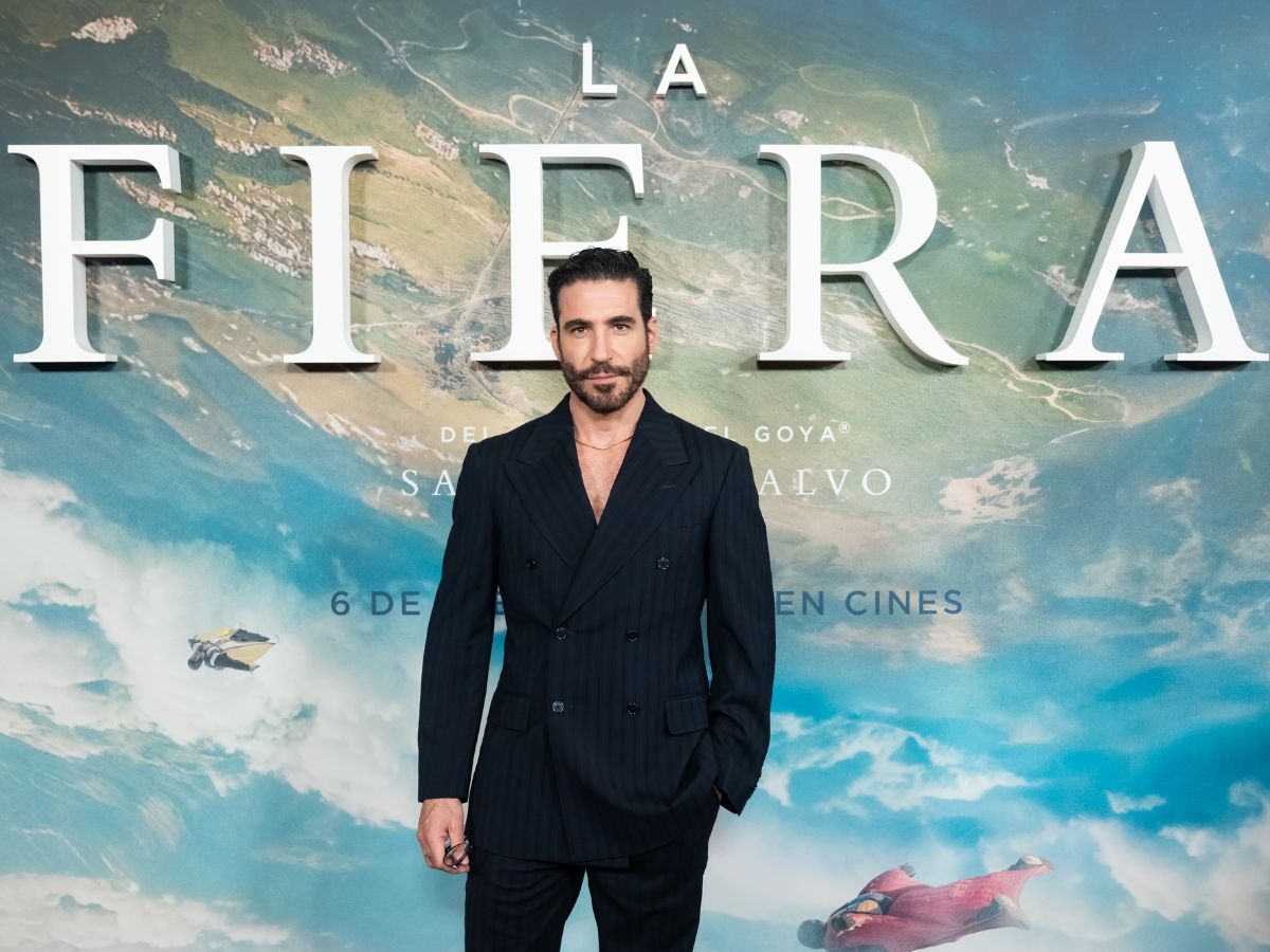 Miguel Ángel Silvestre luce un traje azul marino de rayas en la alfombra roja de la premiere de La Fiera en el cine Capitol de Madrid.
