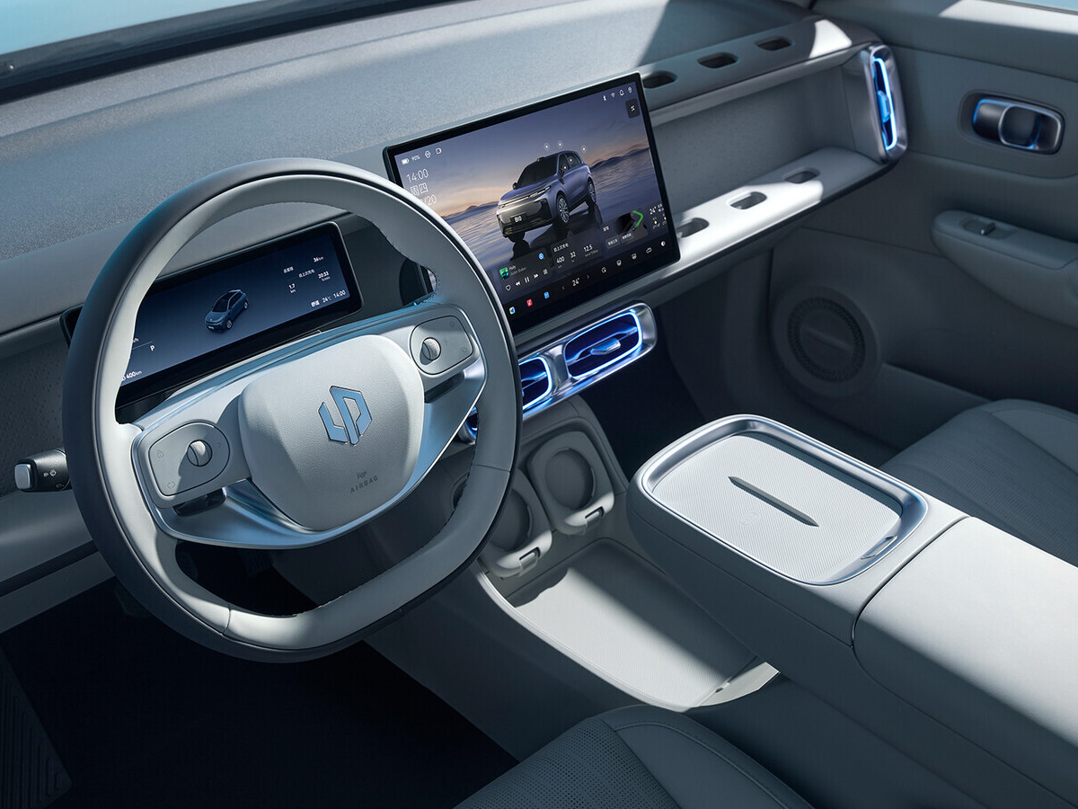 Interior del Leapmotor B10 con volante de diseño minimalista, pantalla central panorámica y consola central despejada en tonos claros.