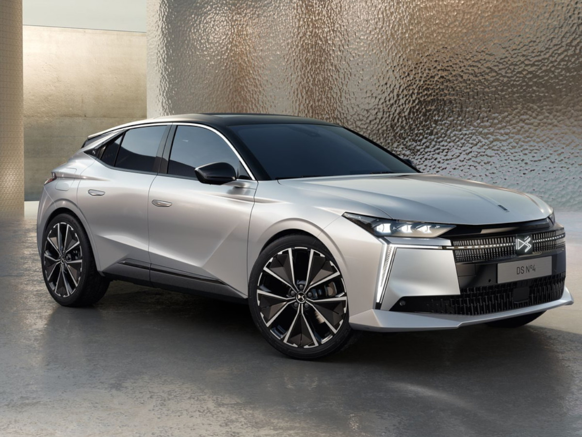 DS 4 de color plateado visto en tres cuartos delanteros, estacionado en un espacio moderno con paredes texturizadas y suelo liso de hormigón.