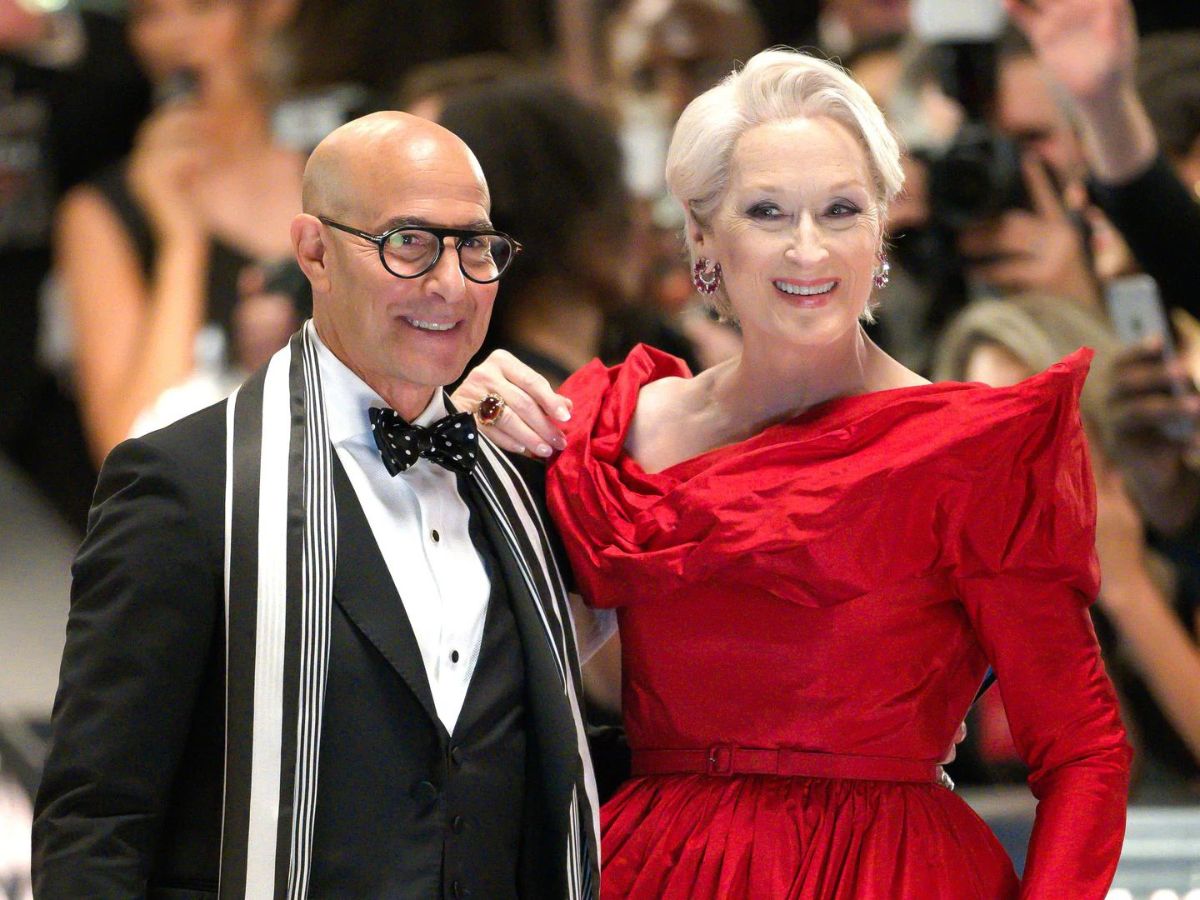 Stanley Tucci con un traje negro y a su derecha Meryl Streep con un vestido rojo en una falsa gala MET en El diablo viste de Prada 2.