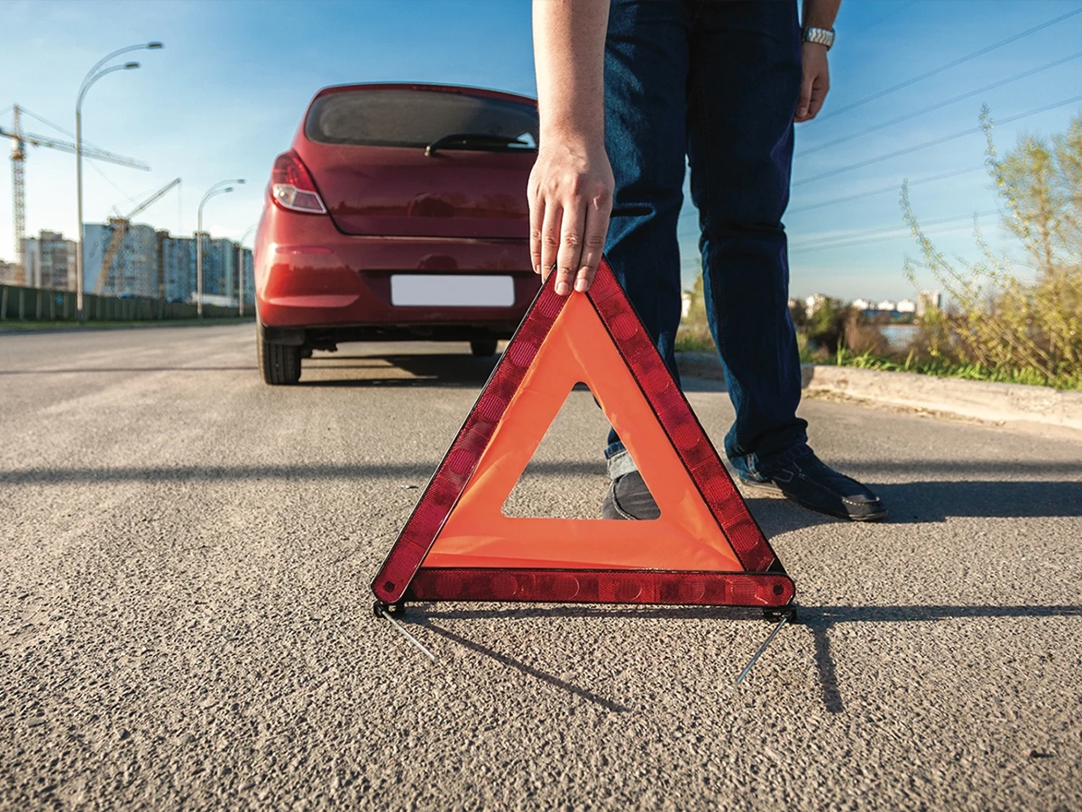 hombre poniendo triángulo en carretera