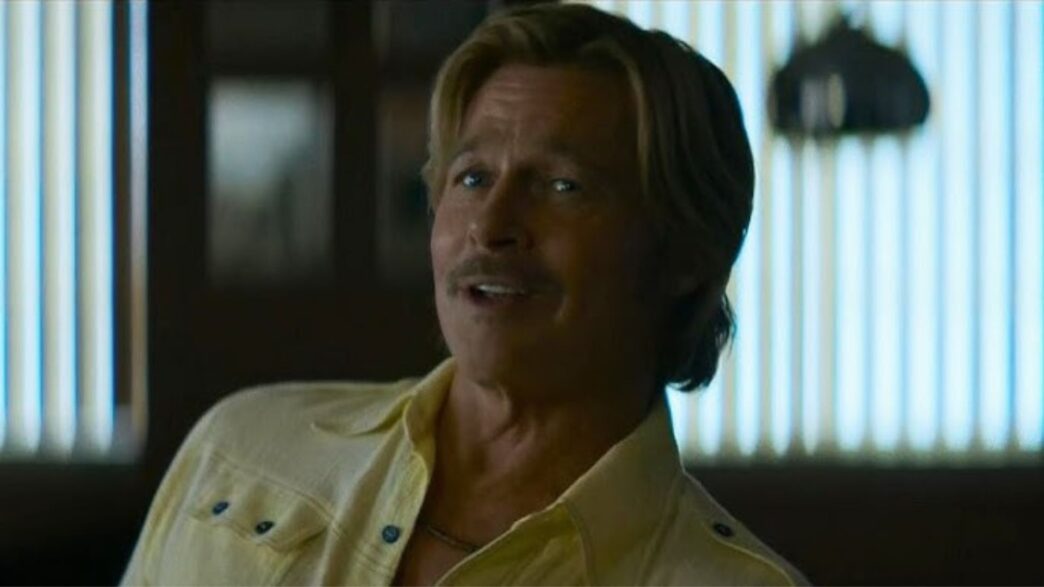 Brad Pitt con camisa amarilla como Cliff Booth en una escena de la película The adventures of Cliff Booth.