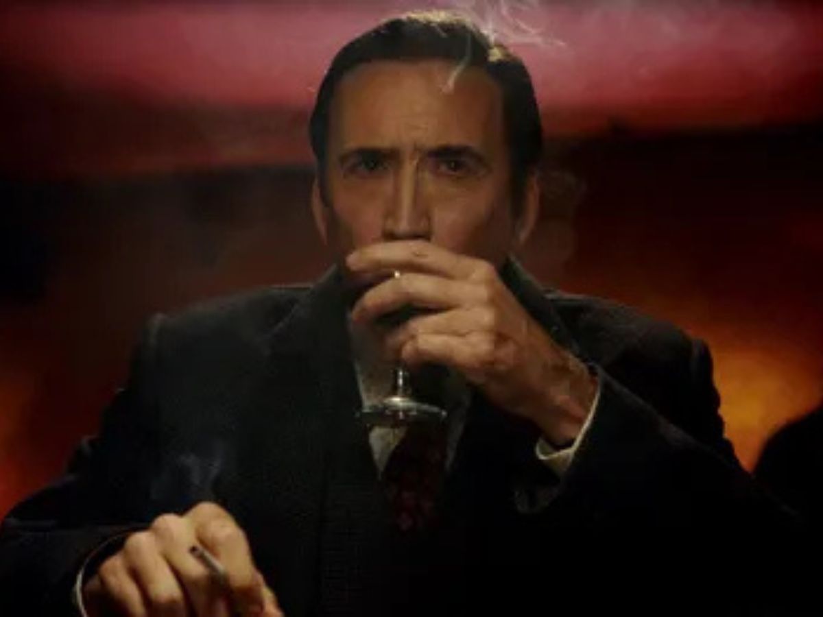 Nicolas Cage cogiendo una copa con la mano izquierda en una escena del tráiler de Spider-Noir.