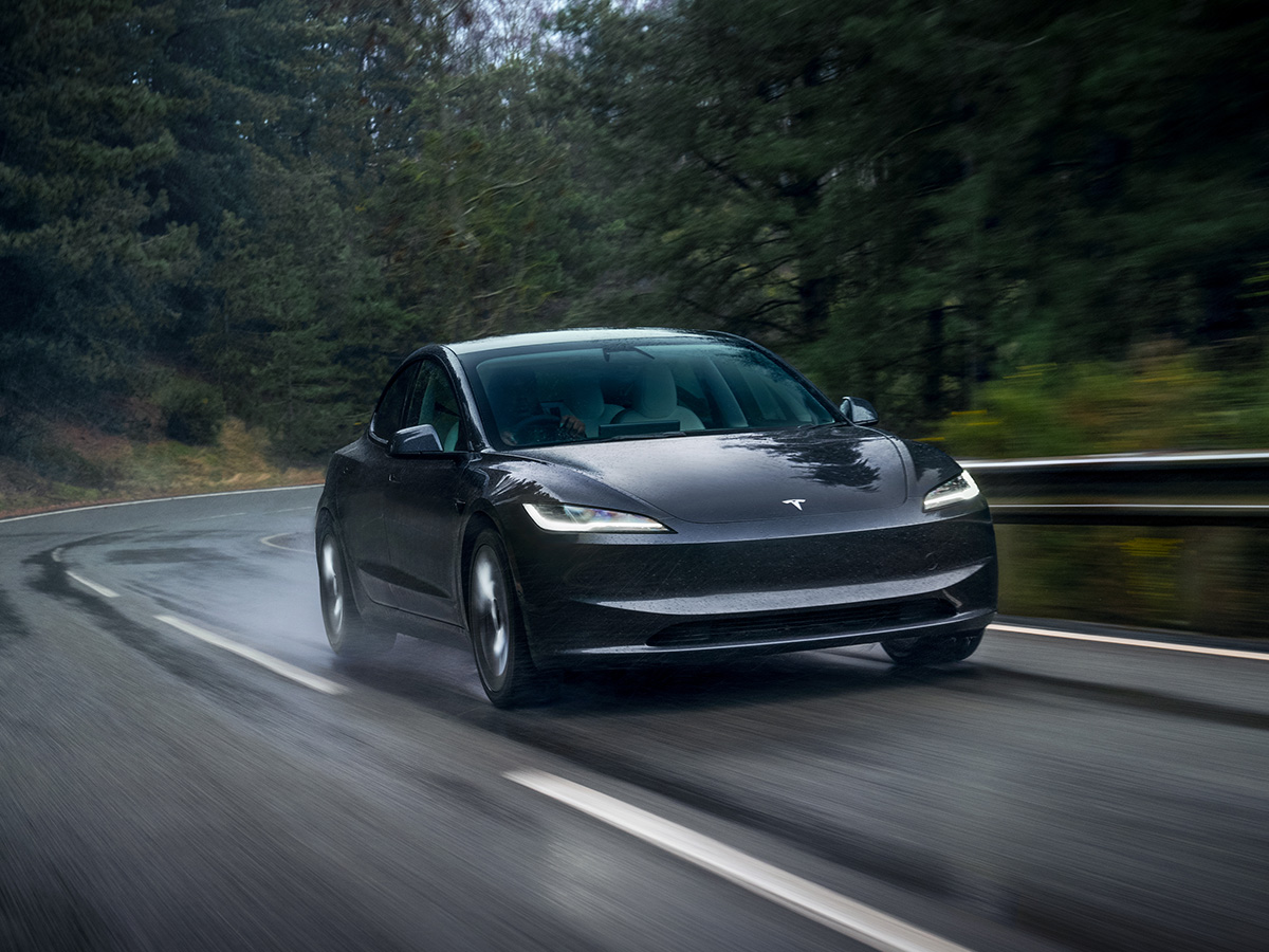 Tesla Model 3 oscuro circulando frontal