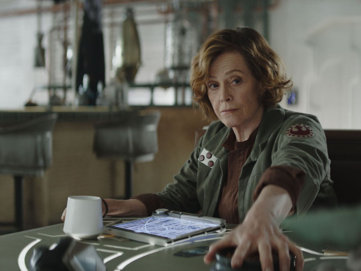 Sigourney Weaver con chaqueta verde sujetando una tablet interpretando a la coronel Ward en The Mandalorian and Grogu.