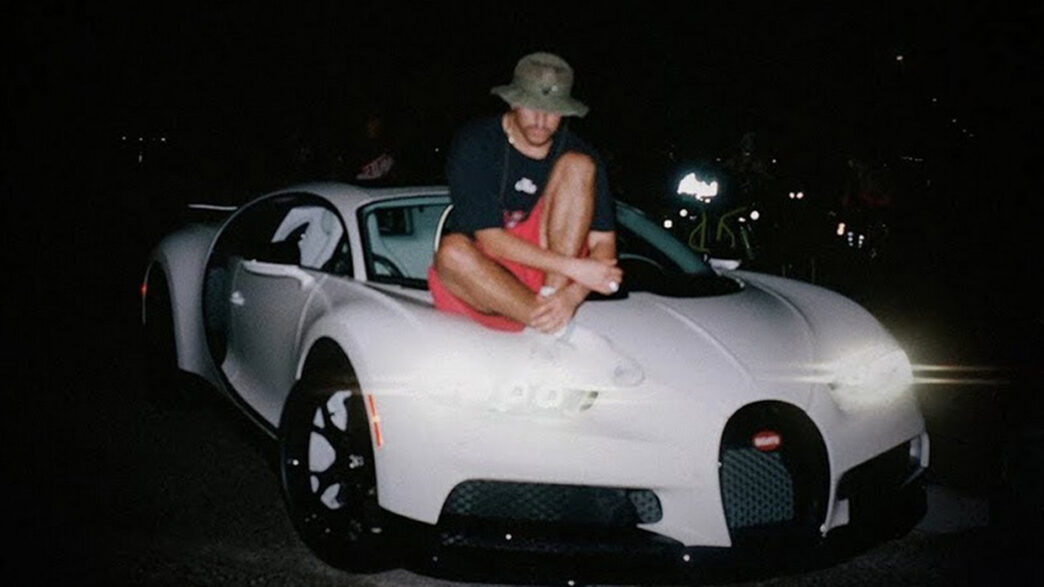 Bad Bunny encima del capó de su Bugatti blanco