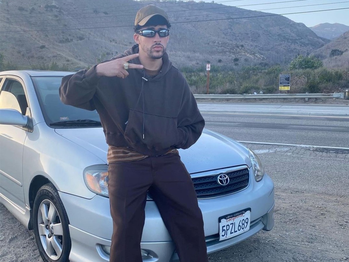 Bad Bunny posa sentado en el capó de su Toyota Corolla