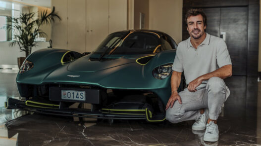 Fernando Alonso posando con uno de sus coches de lujo