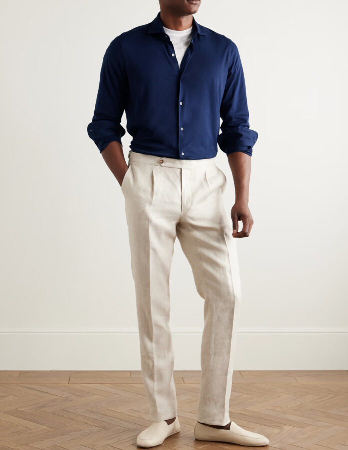 Look de hombre con camisa azul marino y pantalón blanco de pinzas