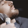hombre afeitándose en una barbería con espuma en la barba
