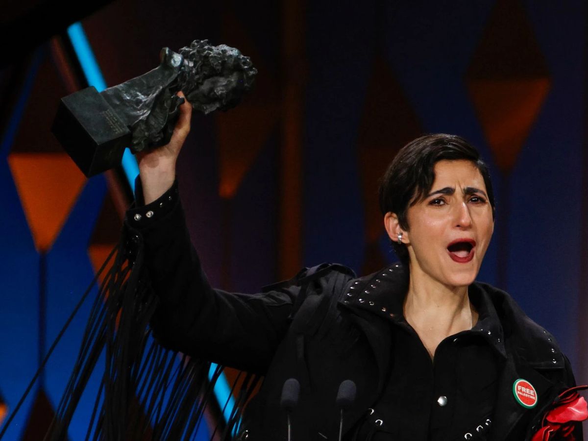 Alba Flores con traje negro levantando el Goya por su canción original en el documental Flores para Antonio.