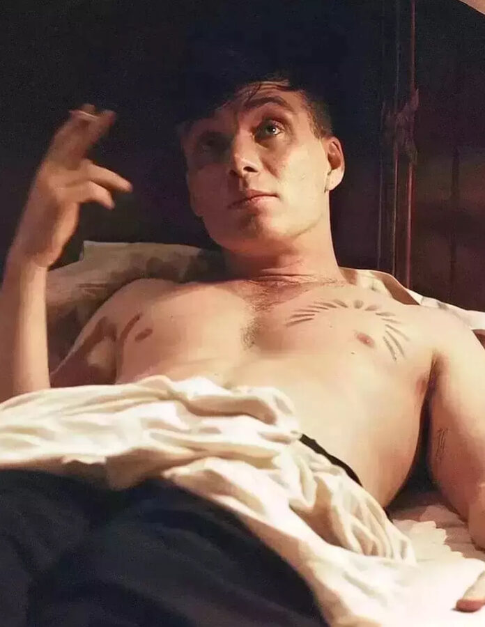 El actor Cillian Murphy tumbado en la cama con tatuajes interpretando su personaje de Shelby Peaky