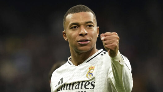 Kylian Mbappé con el puño cerrado y camiseta del Real Madrid