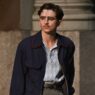 Timothée Chalamet con chaqueta y camisa azul interpretando a Marty Supreme en la película Marty Supreme, nominada al Oscar.