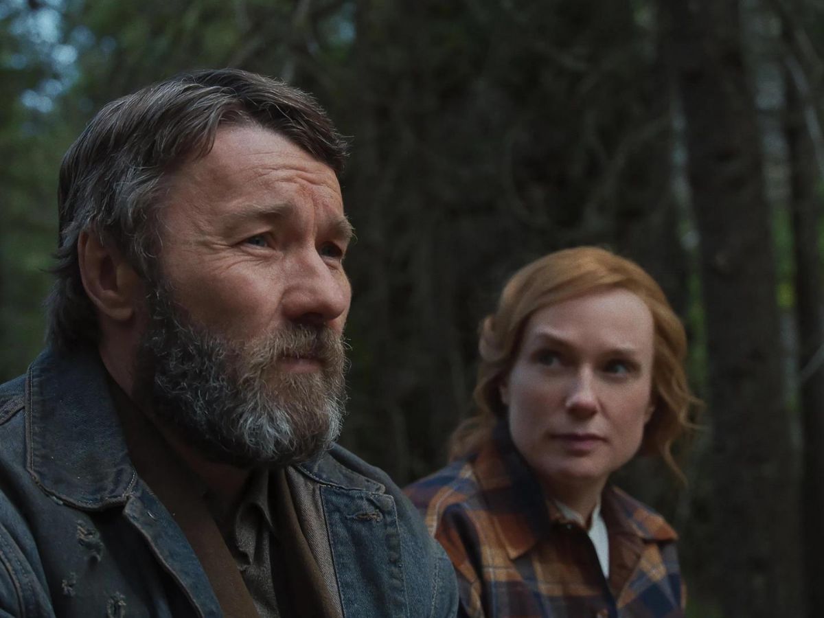 Primer plano del actor Joel Edgerton con barba y la actriz Kerry Condon mirándole en una escena de la película Sueños de trenes.