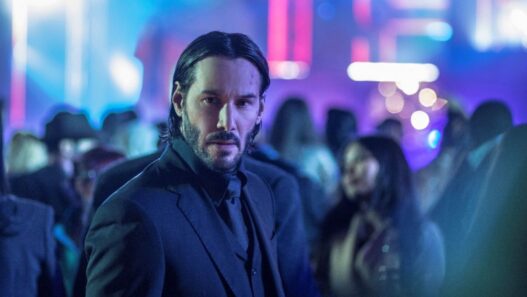 Keanu Reeves con traje en una escena en una discoteca en la película John Wick 4.