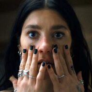 Si te gusta Stranger Things no te puedes perder estas series de sus creadores Primer plano de Camila Morrone tapándose la boca con las manos con expresión de susto en la serie Algo terrible está a punto de suceder.