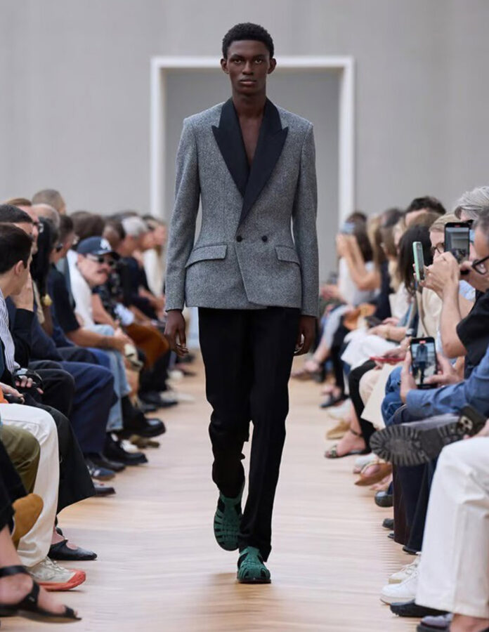 Modelo del desfile de Dior verano 2026 con chaqueta Bar gris en lana virgen