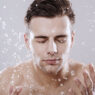 hombre lavándose la cara con agua