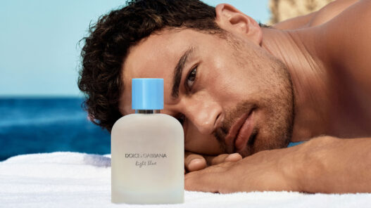 modelo tumbado en toalla mirando perfume Dolce & Gabbana