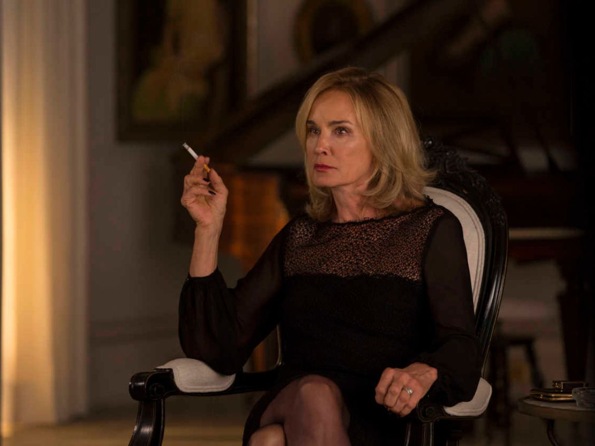Jessica Lange vestida de negro y fumando un cigarro en American Horror Story Coven.