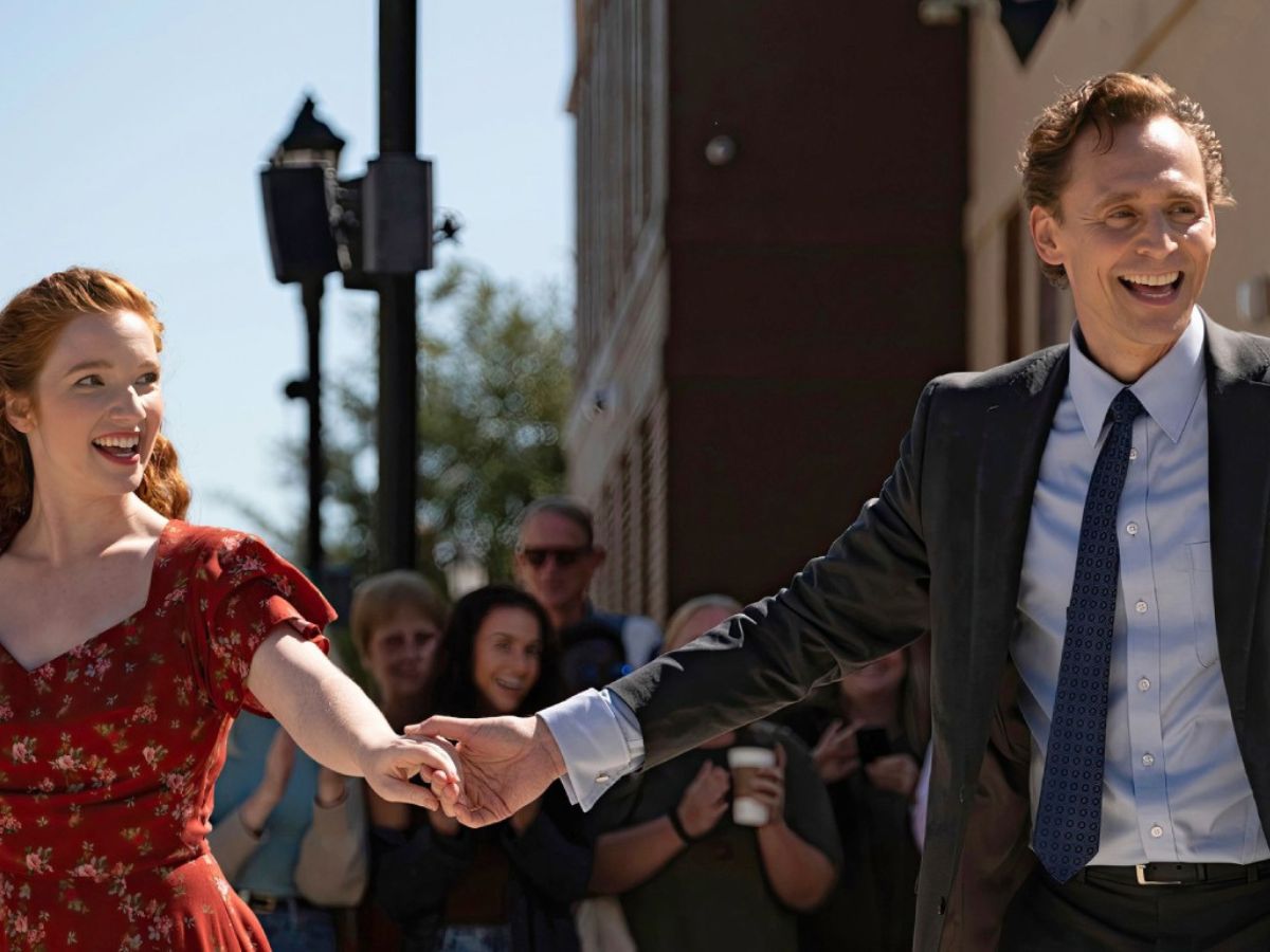 Tom Hiddleston agarrando de la mano a Mia Sara bailando en una escena de la película La vida de Chuck.