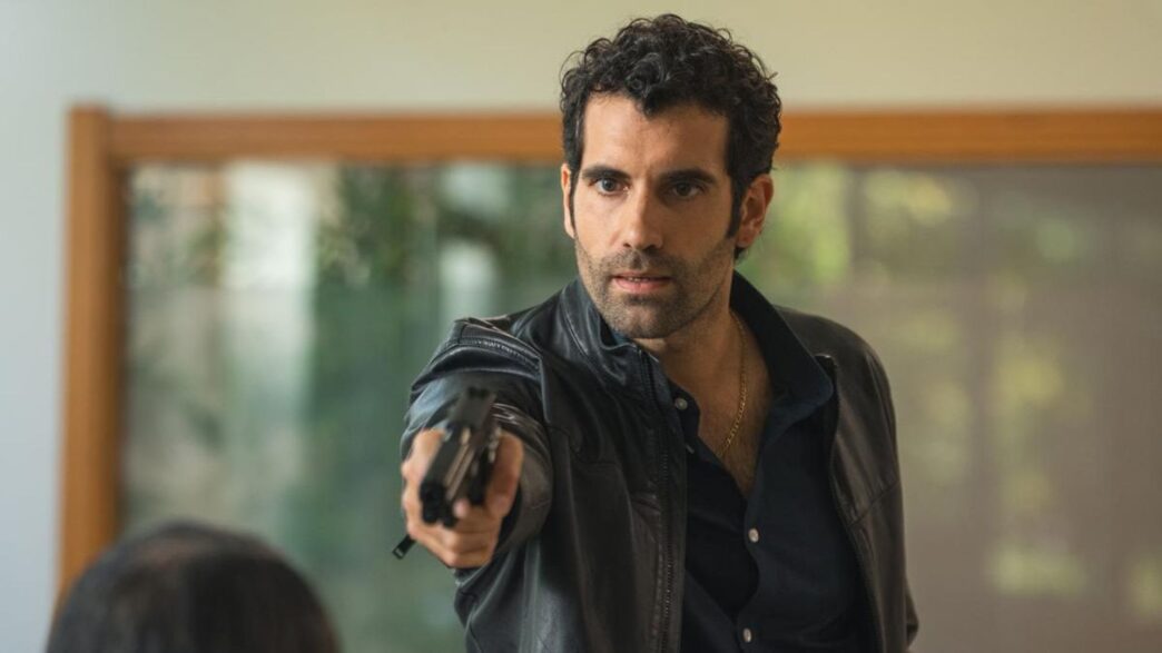 Primer plano de Tamar Novas apuntando con una pistola en la segunda temporada de Clanes en Netflix.