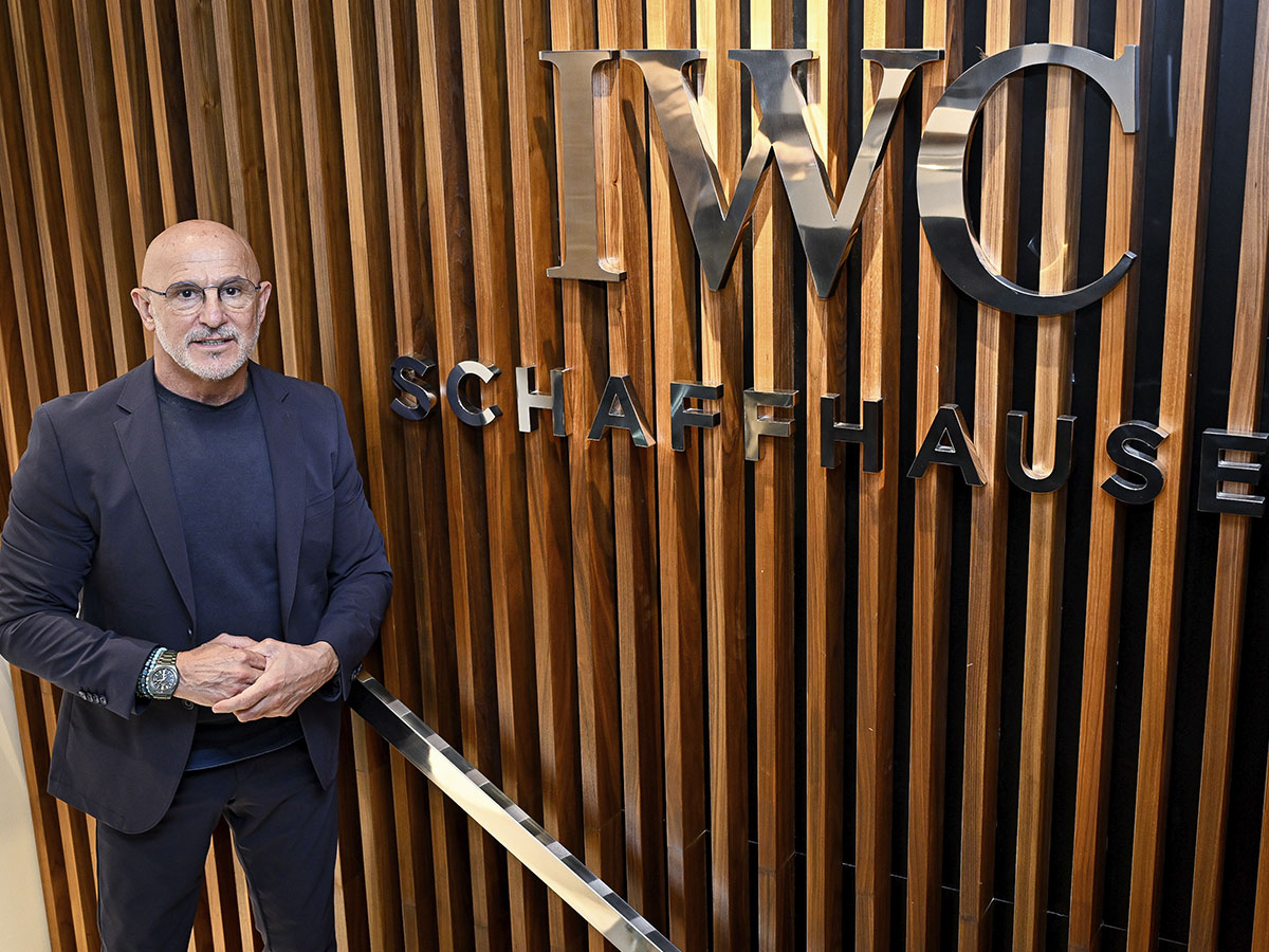Luis de la Fuente posa junto al logotipo de IWC Schaffhausen en la boutique de Madrid