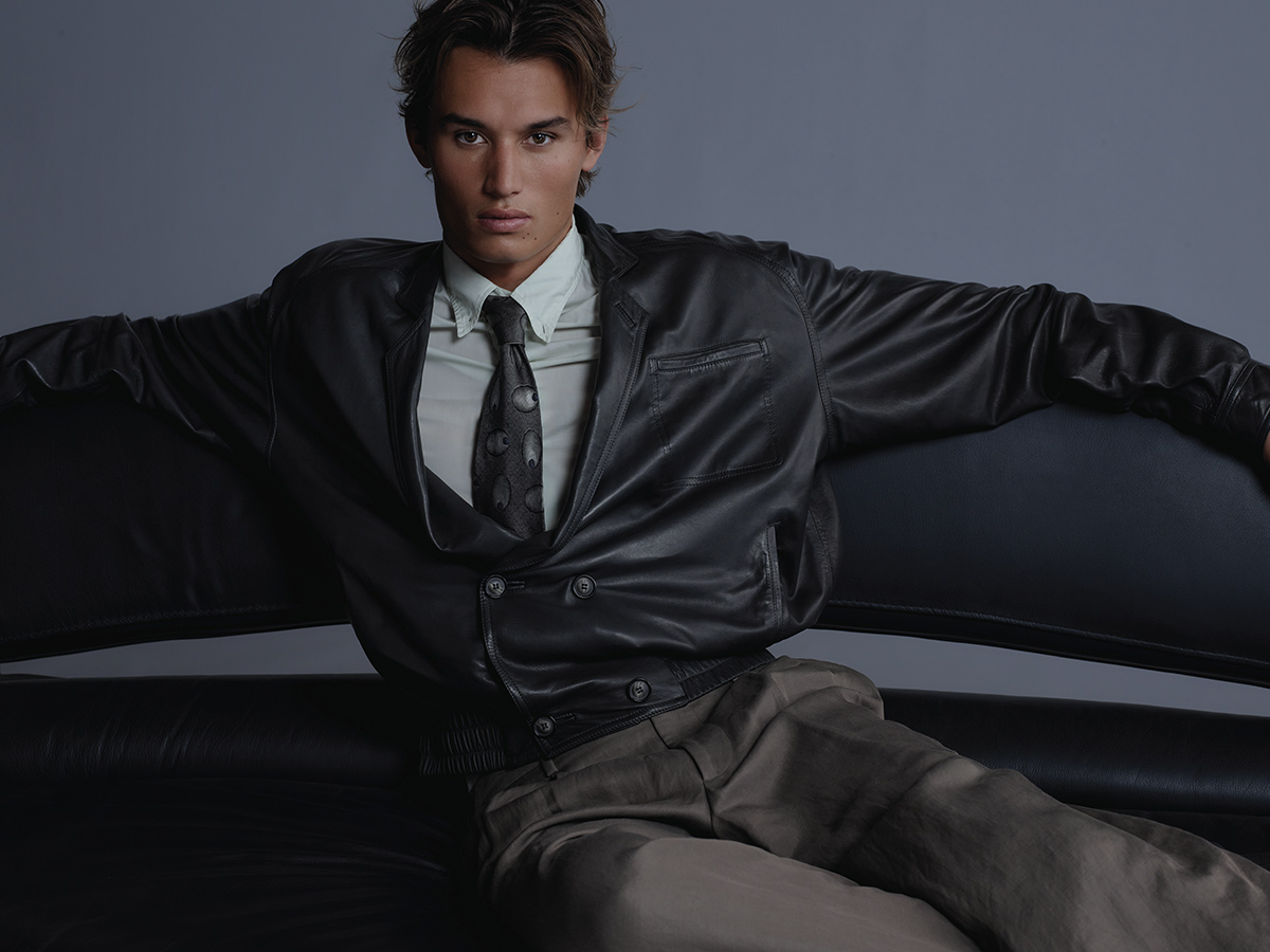 odelo con chaqueta de cuero negra y pantalón beige de la colección Armani/Archivio